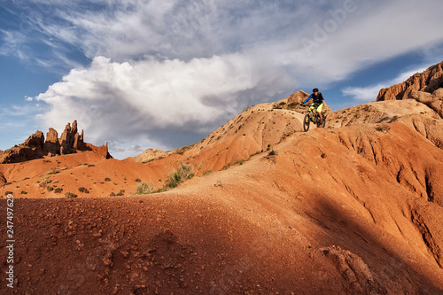 Cyclist riding a mountain bike downhill style in a canyon 