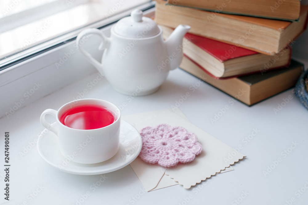 Cup of tea and teapot on white windowsill, morning springtime concept Cup of tea and teapot on white windowsill, morning springtime concept