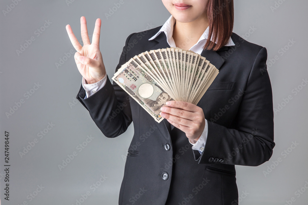 スーツの女性が笑顔で何十万のお金を両手で持つ稼ぎ方 スーツの女性が笑顔で何十万のお金を両手で持つ稼ぎ方