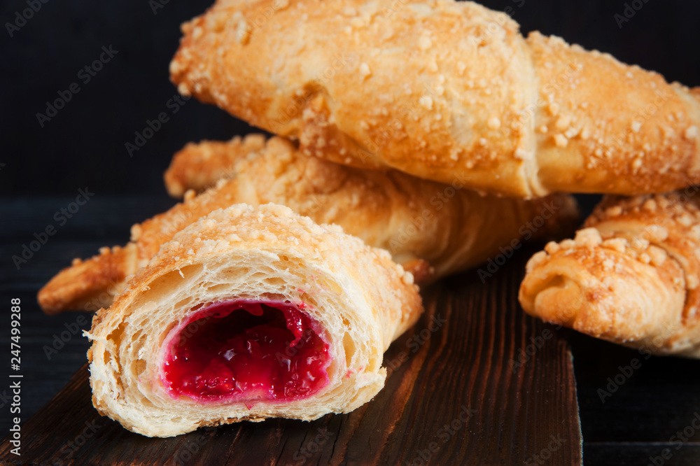 Croissants with raspberries on wooden cutting board. Croissants with raspberries on wooden cutting board.