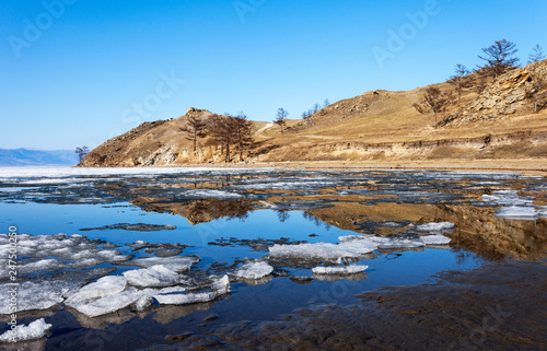 Spring sunny day on the shore of Lake Baikal. Ice floes are melting on the shores of the Kurkutsky Bay of the Small Sea © Katvic