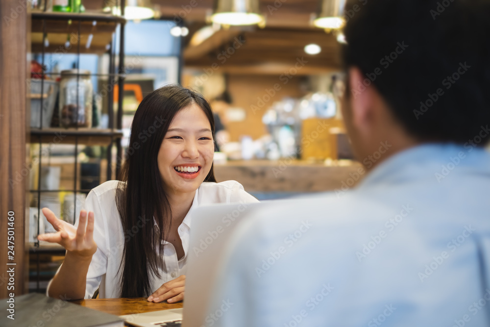 Young beautiful asian business woman in cafe, discussing business during interview with young business man
