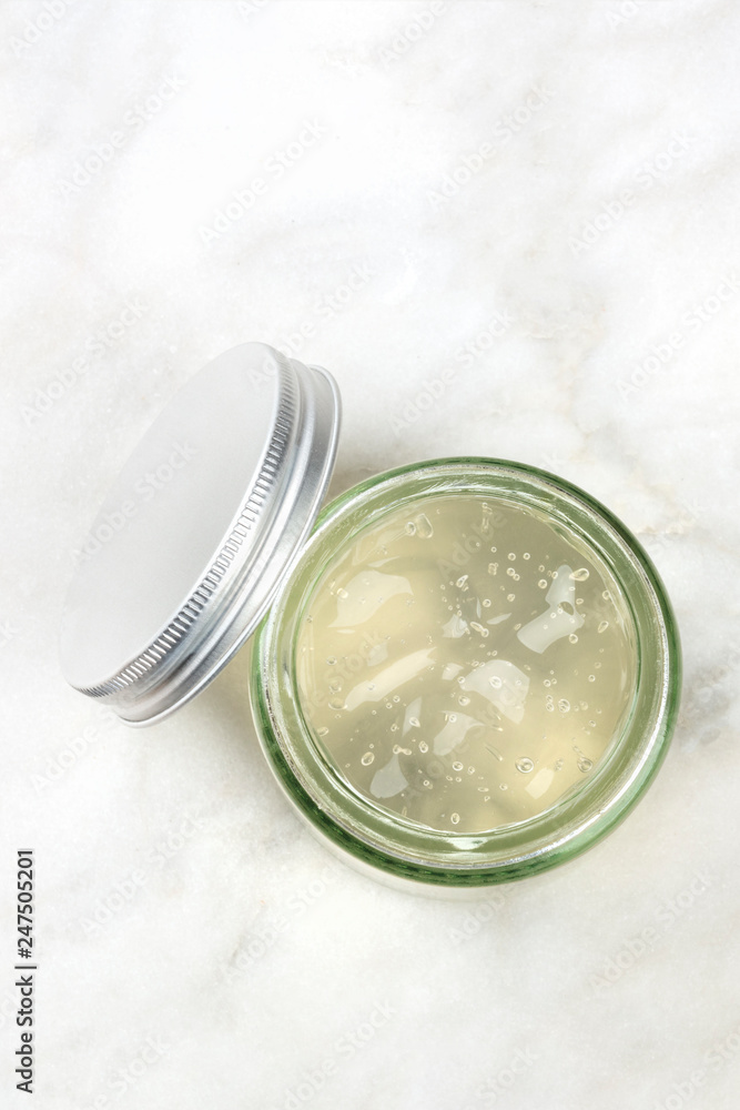 A photo of a glass jar with aloe vera gel, shot from above on a white marble background with copy space A photo of a glass jar with aloe vera gel, shot from above on a white marble background with copy space