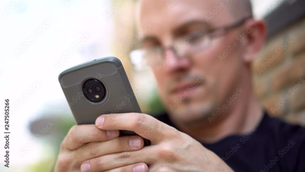 20s Caucasian Man Texting Using Smartphone Outdoors 20s Caucasian Man Texting Using Smartphone Outdoors