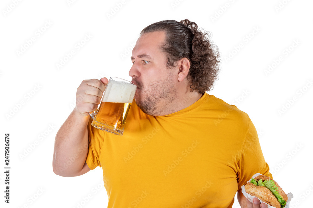 Funny fat man eating burger and drinking alcohol beverage on white background Funny fat man eating burger and drinking alcohol beverage on white background