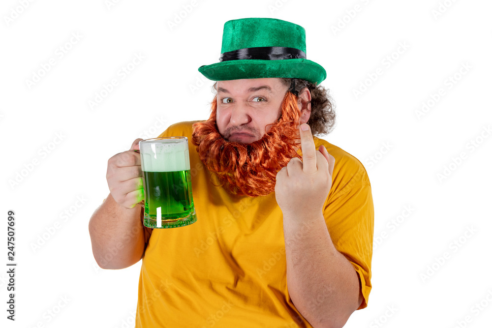 A smiling happy fat man in a leprechaun hat with green beer at studio. He celebrates St. Patrick A smiling happy fat man in a leprechaun hat with green beer at studio. He celebrates St. Patrick