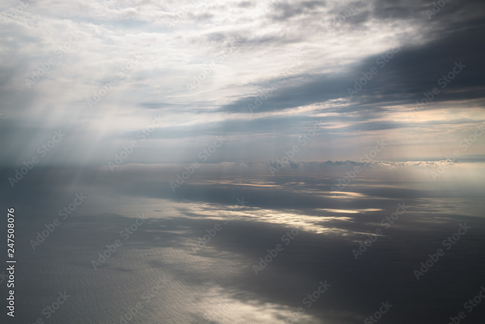 sun's rays illuminate the surface of the sea through the clouds