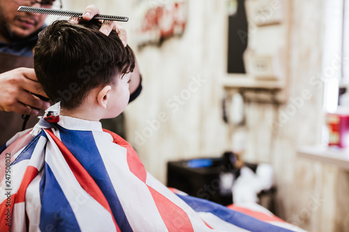Young boy cuts his hair in the modern hairdresser