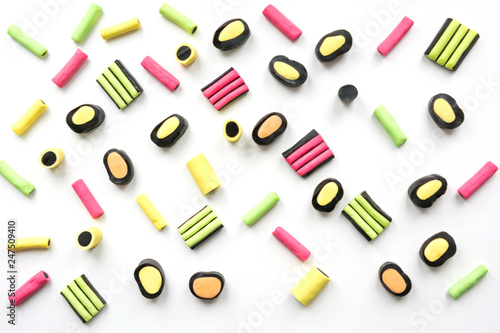 Colorful lollipop and licorice candy on white. View from above. Concept banner for design. Flat lay.