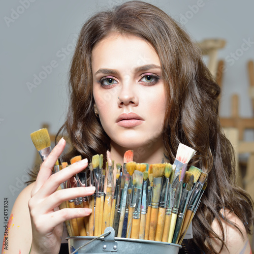 woman with brushes painting at art studio