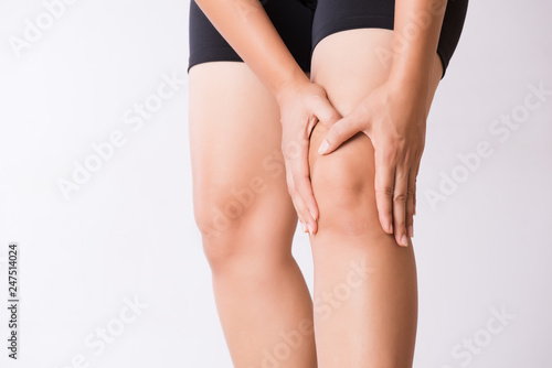 Runner sport knee injury. Closeup young woman in knee pain while running. Healthcare and medical concept.