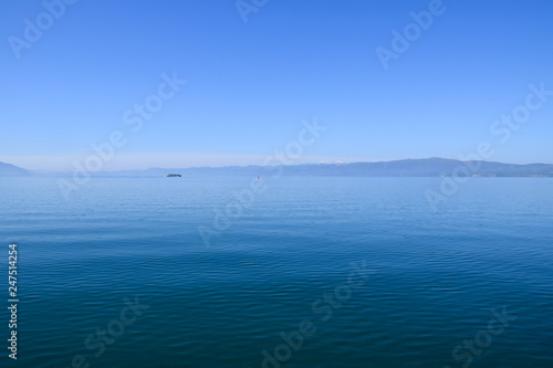 Tourist ship is sailing on Ohrid Lake. Mountain background. Ohrid, Macedonia.