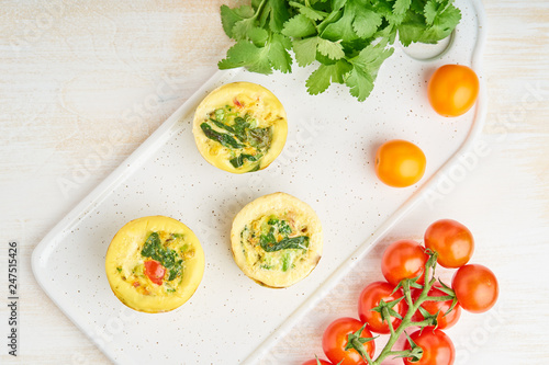Egg muffins, paleo, keto diet. Omelet with spinach, vegetables, tomatoes baked in small molds, top view