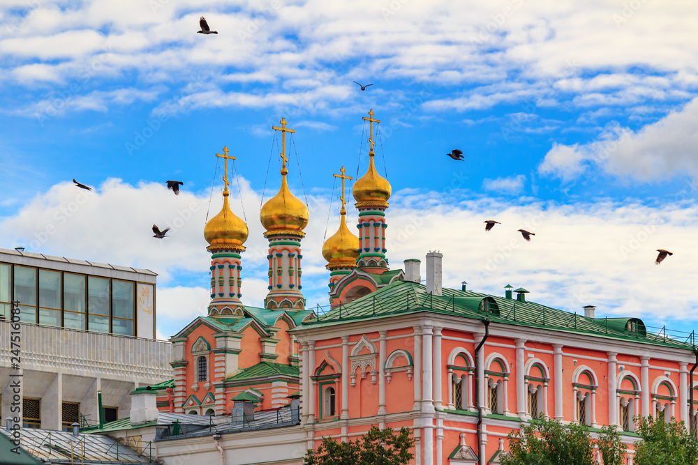 Dormition Cathedral on a background of buildings of Moscow Kremlin against blue sky with clouds
