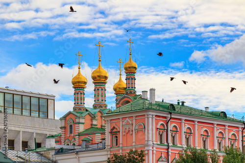 Dormition Cathedral on a background of buildings of Moscow Kremlin against blue sky with clouds