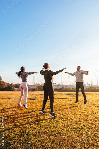 Personal trainer training two girls outdoor