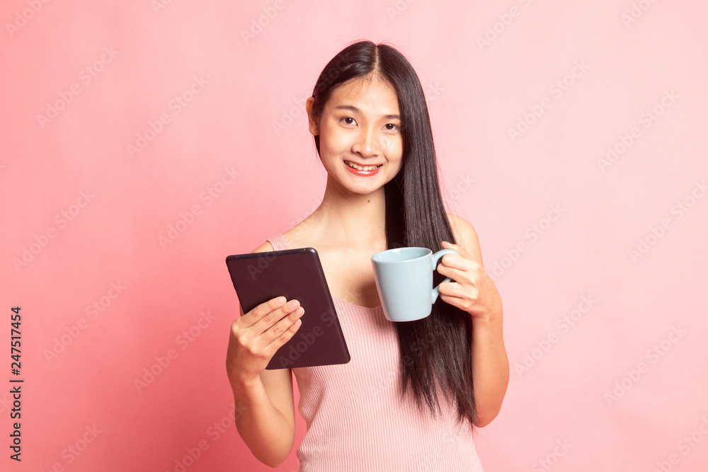 Young Asian woman with a computer tablet and coffee. Young Asian woman with a computer tablet and coffee.