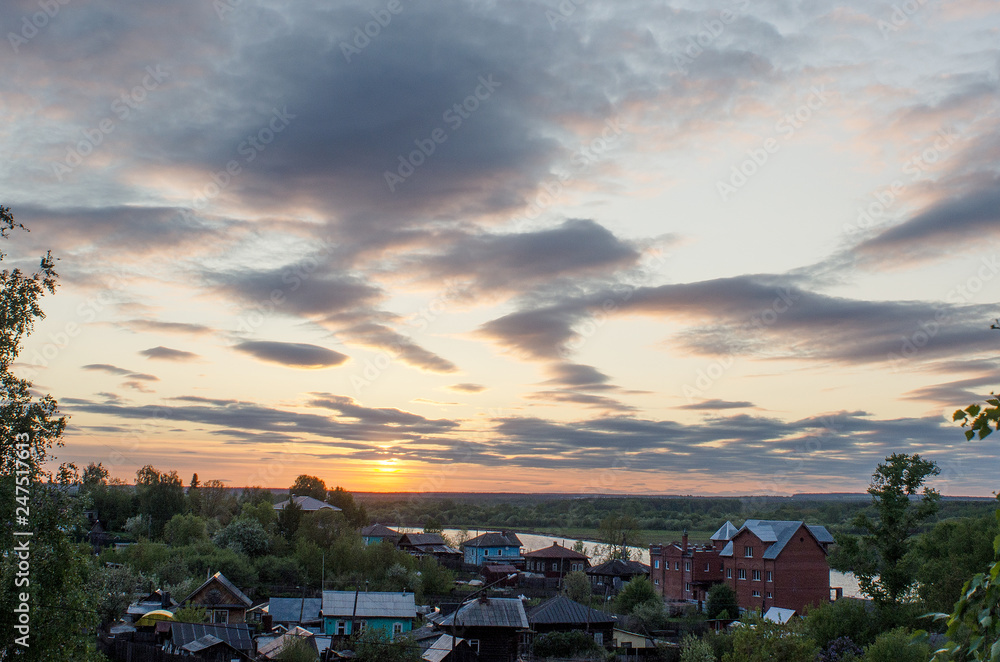 Cumulus clouds of fantastic shape soar in the sky in the sun's rays over the visible horizon line. Cumulus clouds of fantastic shape soar in the sky in the sun's rays over the visible horizon line.