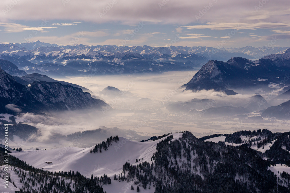 Blick vom Geigelstein auf Nebel und schneebedeckte Bergkette