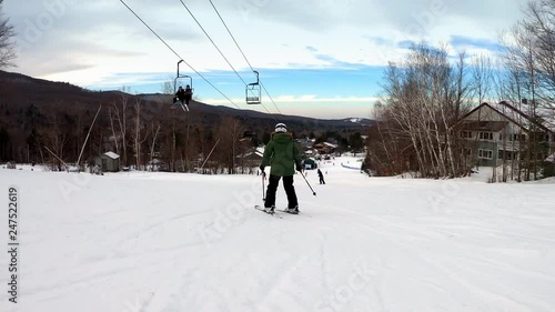Female skier going down the slope and making turns. Woman skier having fun on a groomed trail and making turns. Active woman. Beautiful Vermont winter vacation. First person view, wide to medium shot.
