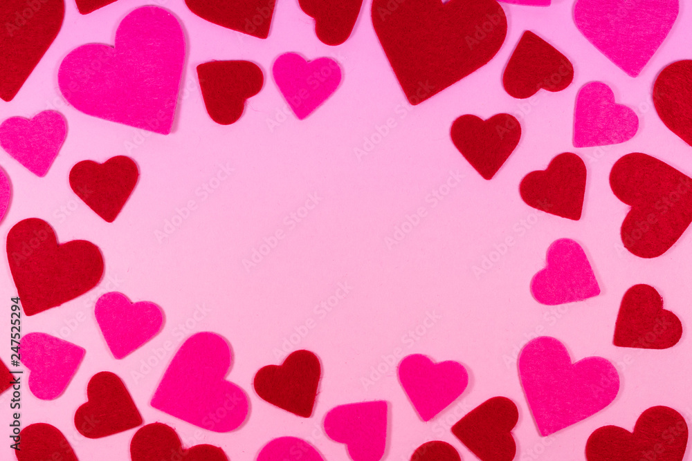 Pink Saint Valentine's day background with red and pink hearts, copy space at the center