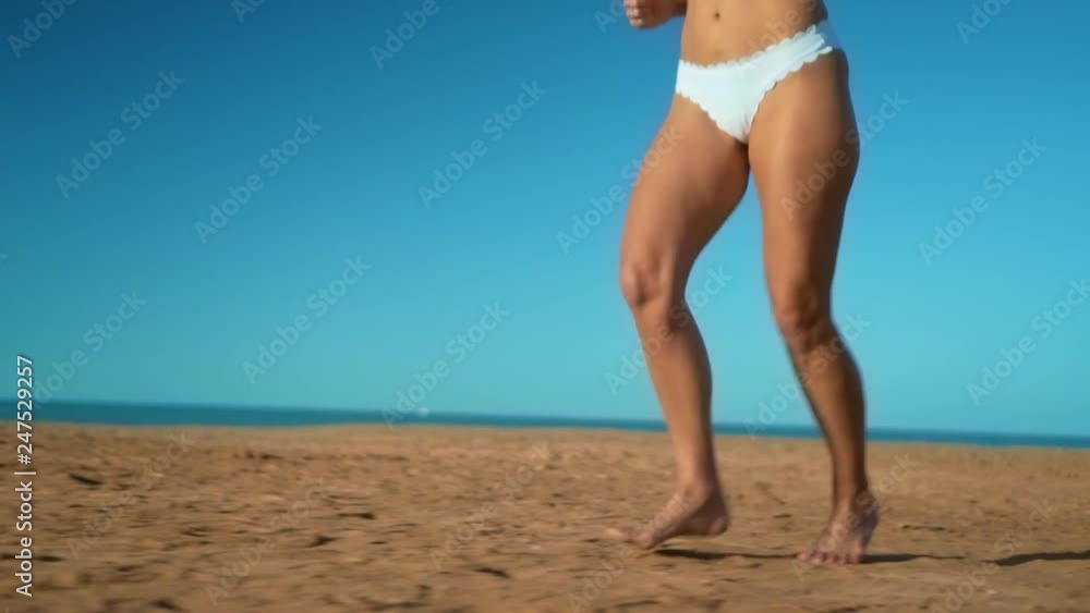 The Female feet run barefoot on shore at sunset. Legs of young woman runing along ocean beach during sunrise. The Female feet run barefoot on shore at sunset. Legs of young woman runing along ocean beach during sunrise.