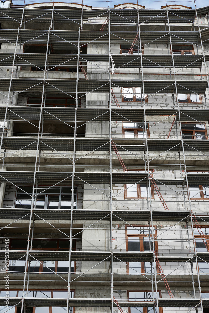 new building under construction, scaffolding and concrete new building under construction, scaffolding and concrete