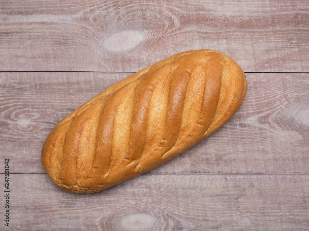 Loaf of bread on a light brown wooden background Loaf of bread on a light brown wooden background