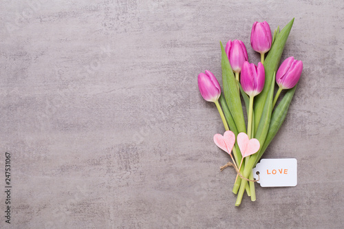 Spring greeting card, pink color tulips on the gray background.