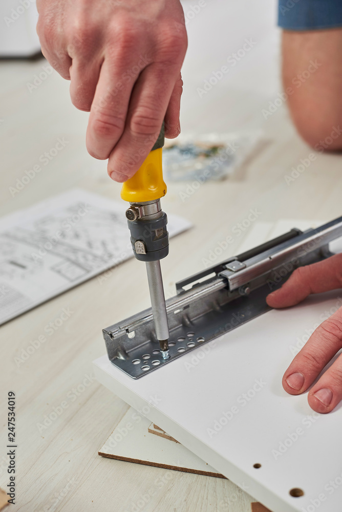 The furniture assembler joins together the two parts of the ready-to-assemble furniture with cam lock connections and wooden dowel pin, flat pack furniture assembly service, snap-together joints