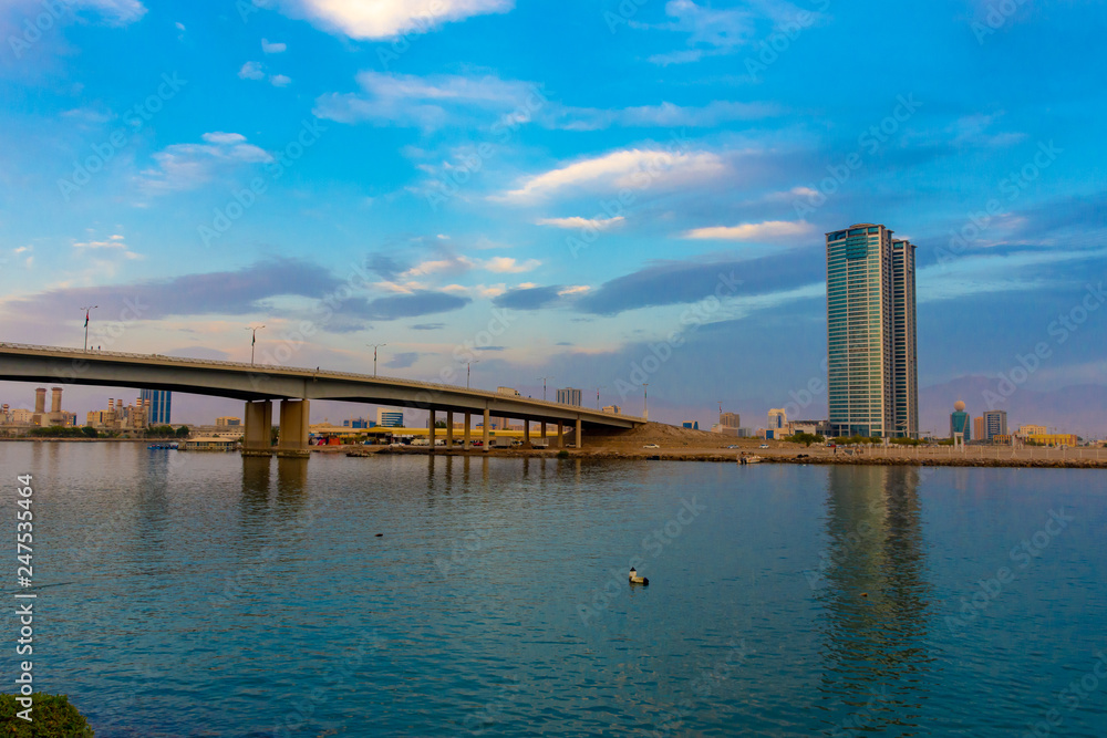 Ras Al Khaimah City in the United Arab Emirates in the late afternoon at the Corniche with the crisp clear blue colored mountain view towards the bridge and Julphar Towers.