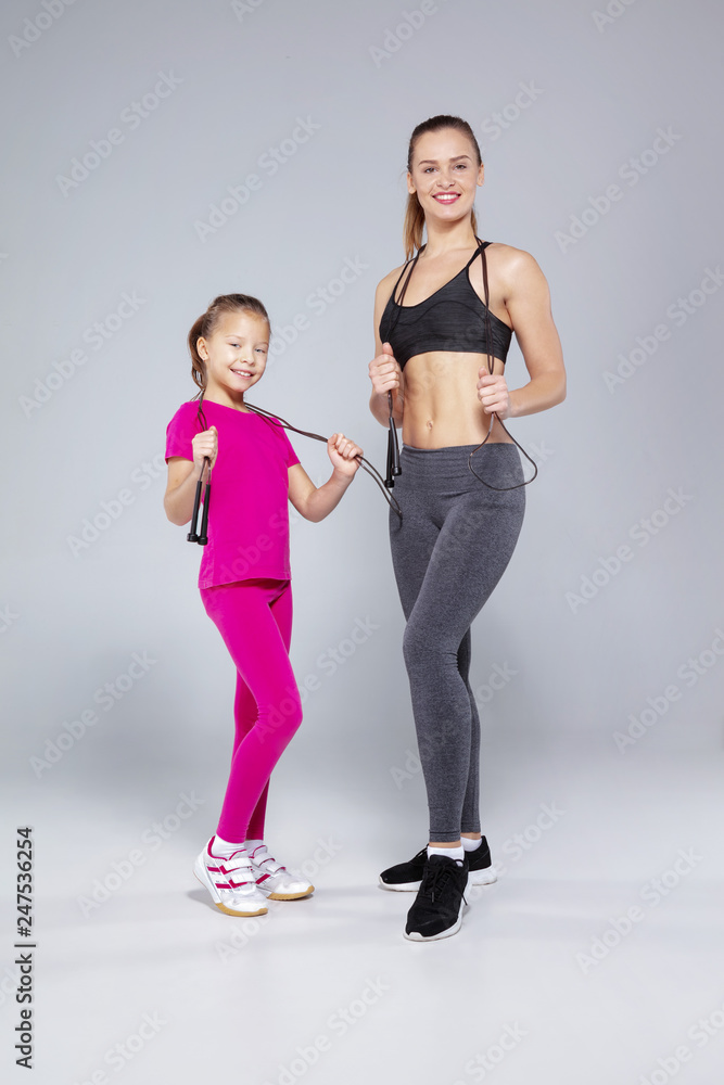 Sportive woman and her daughter with jumping rope Sportive woman and her daughter with jumping rope