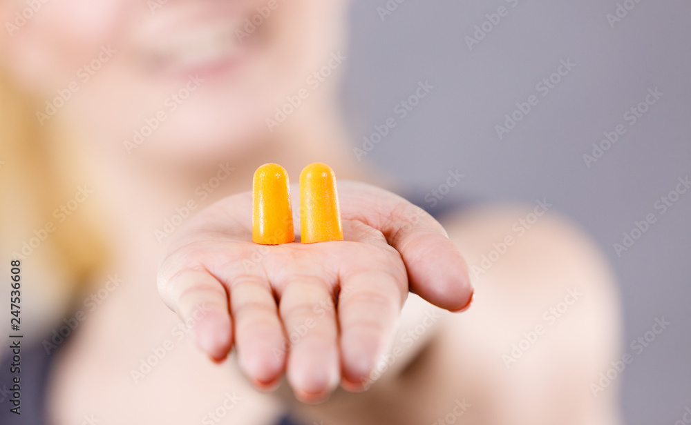 Woman holding protective earplugs Woman holding protective earplugs