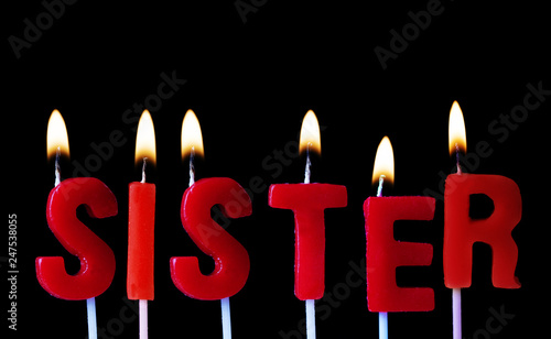 Photography Sister spellt out in red birthday candles against a black background