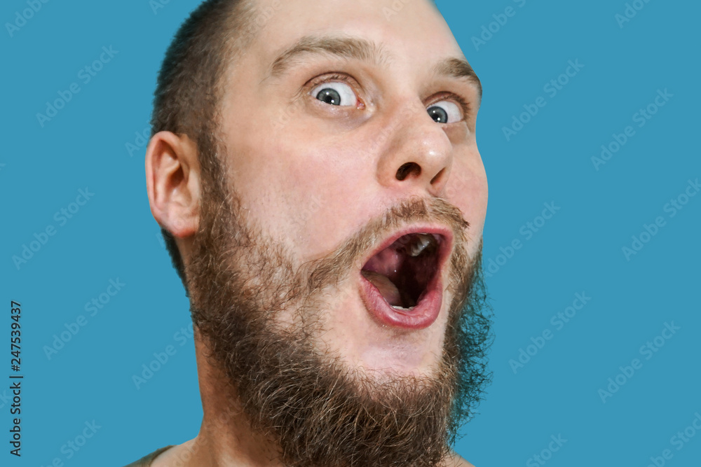 Very surprised scared funny face of a bearded guy with open mouth and big  eyes on an isolated background Stock Photo | Adobe Stock