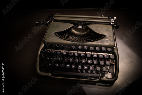 Old fashion typewritter on dark foggy background. Close up of vintage typewritter machine