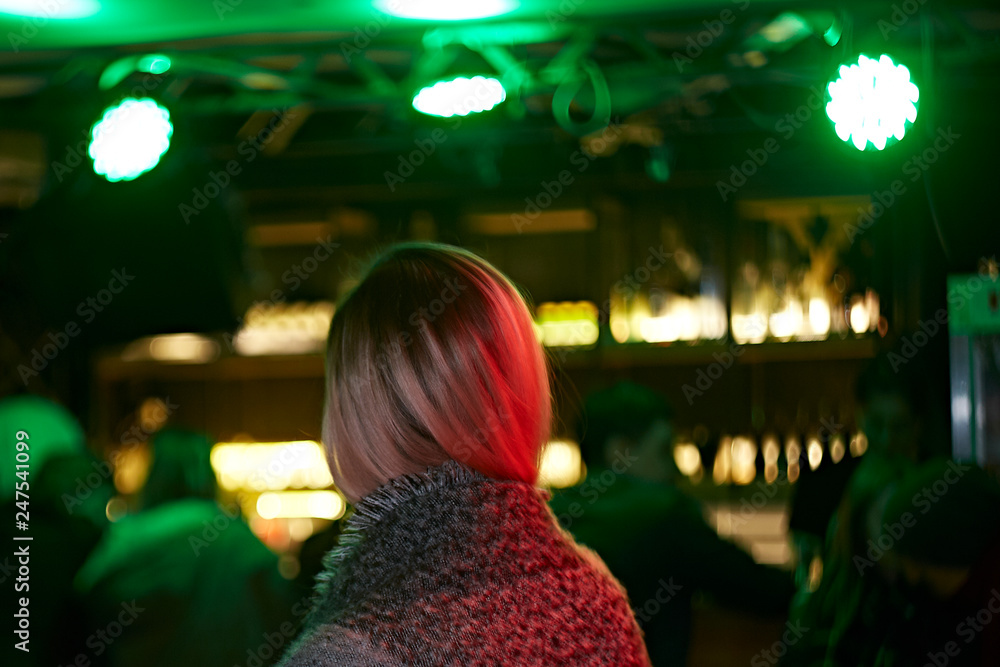 Obraz premium Back view of a blonde girl in a bar