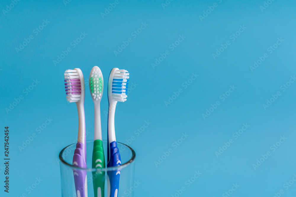Cup with toothbrushes against color background. Dental care Cup with toothbrushes against color background. Dental care