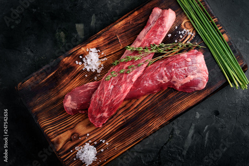 beef tenderloin on a wood Board with salt and thyme top view, skirt steak