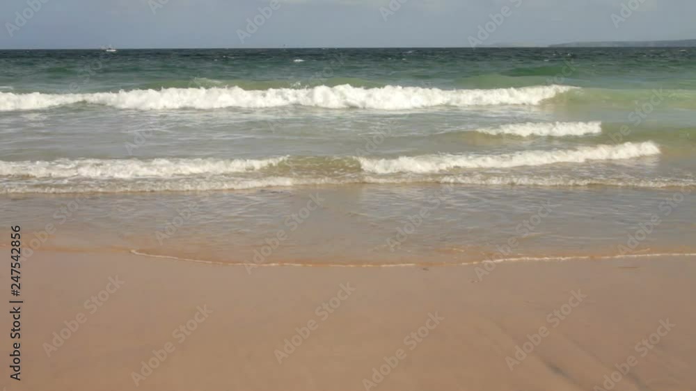 Waves gently rolling onto the sandy beach Waves gently rolling onto the sandy beach