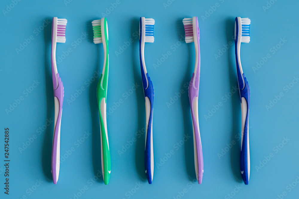 Toothbrushes on blue background. Flat lay composition with manual toothbrushes on color background, close up Toothbrushes on blue background. Flat lay composition with manual toothbrushes on color background, close up