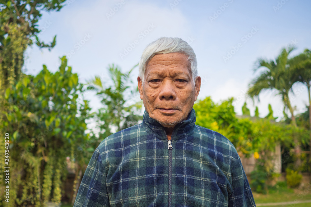 Portrait of elderly man standing in his garden.