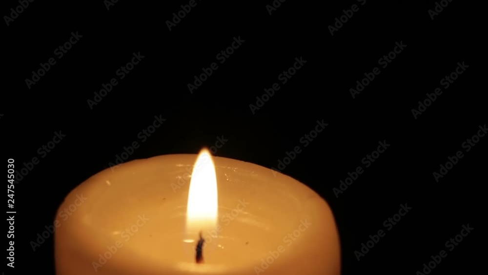 The candle burns in the dark isolated The candle burns in the dark isolated