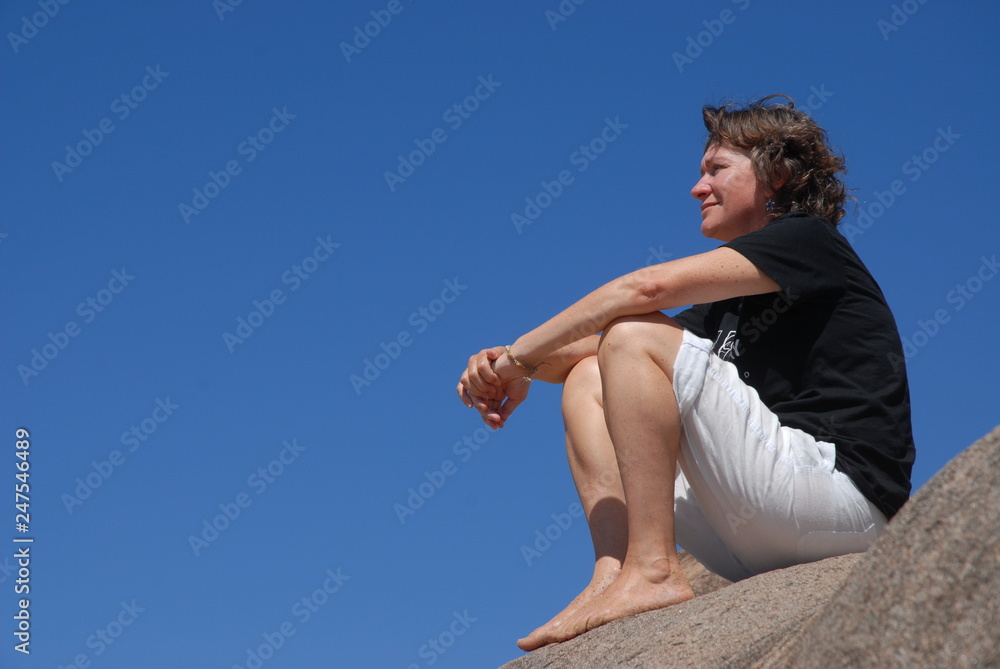 Woman sitting on a rock, Magnetic Island, Australia Woman sitting on a rock, Magnetic Island, Australia