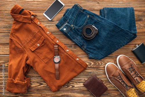 Flat lay with clothes, smartphone and wallet on wooden background