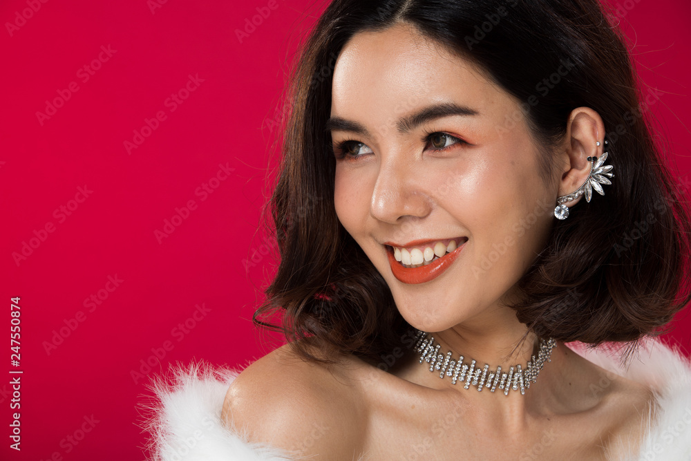Fashion portrait of Asian Black hair tanned skin woman with strong super color red lips wearing white fur diamond earrings necklace, studio lighting red reddish background, holding liquid lipstick Fashion portrait of Asian Black hair tanned skin woman with strong super color red lips wearing white fur diamond earrings necklace, studio lighting red reddish background, holding liquid lipstick