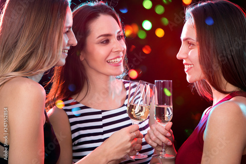 Beautifully dressed girls with glasses of wine at a Christmas party