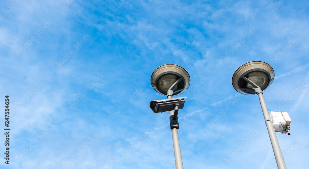 City cctv security surveillance camera system attached on the traffic light pole with clear blue sky background