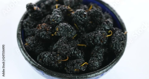dry black mulberry on white background