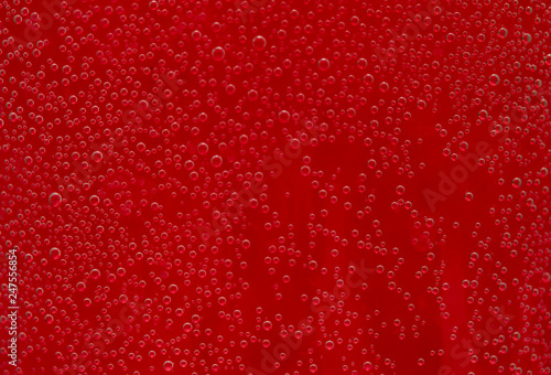 round air droplets in water on a red background